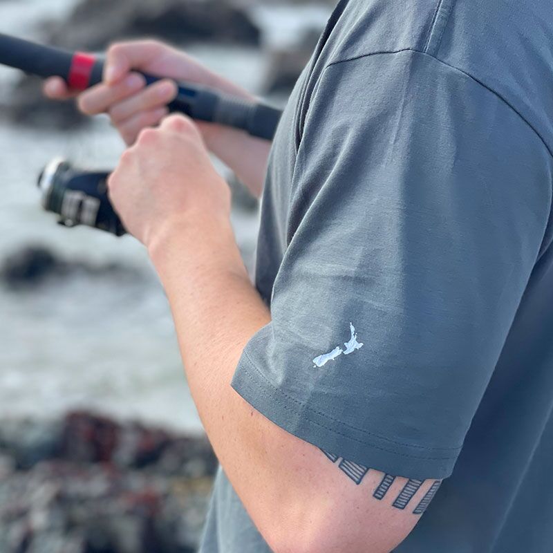 Close up go man rock fishing wearing Snapper 1 T-shirt in AS Colour Charcoal